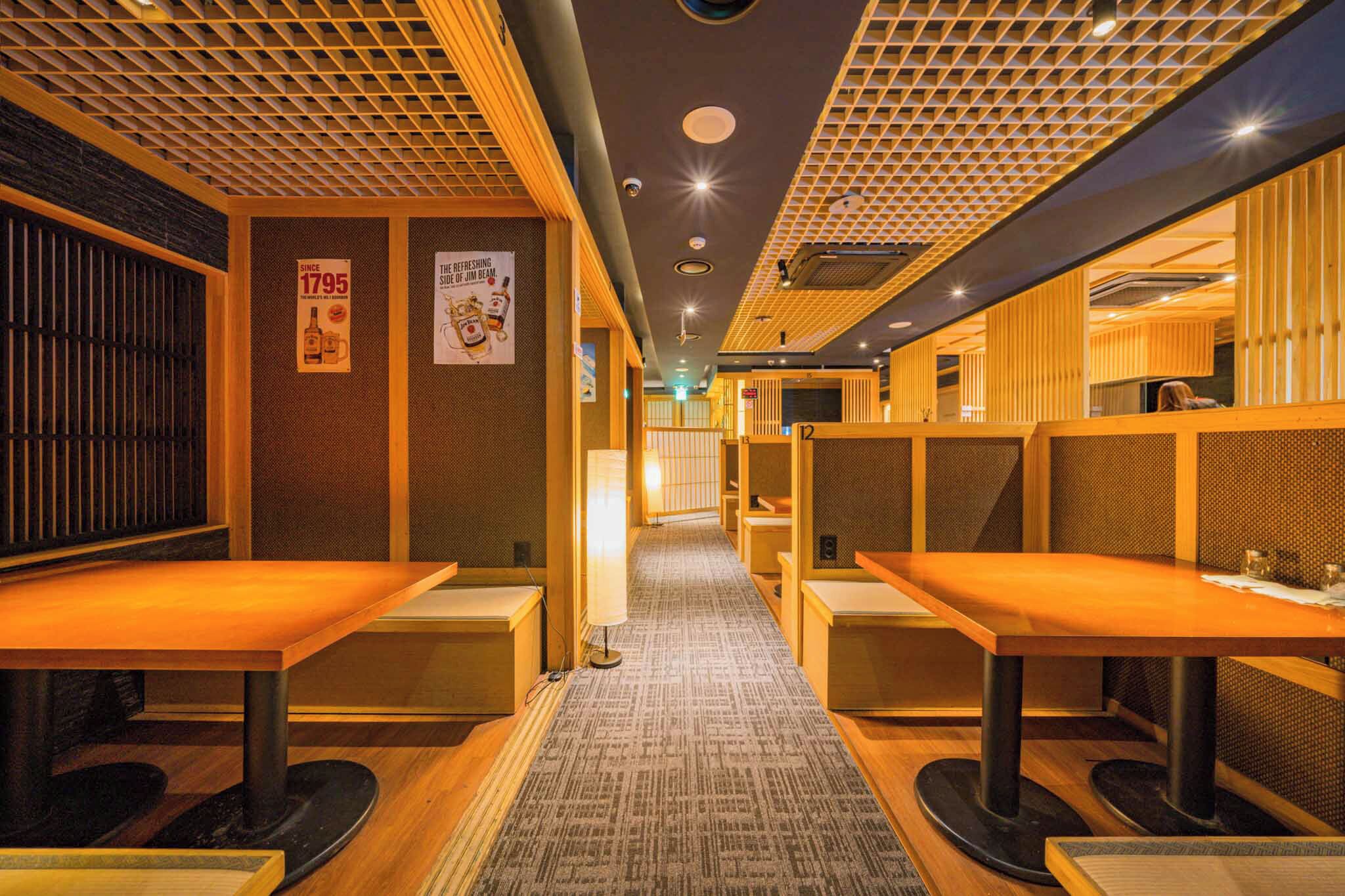Een restaurant met zitjes, een kamerbreed tapijt en houten details.