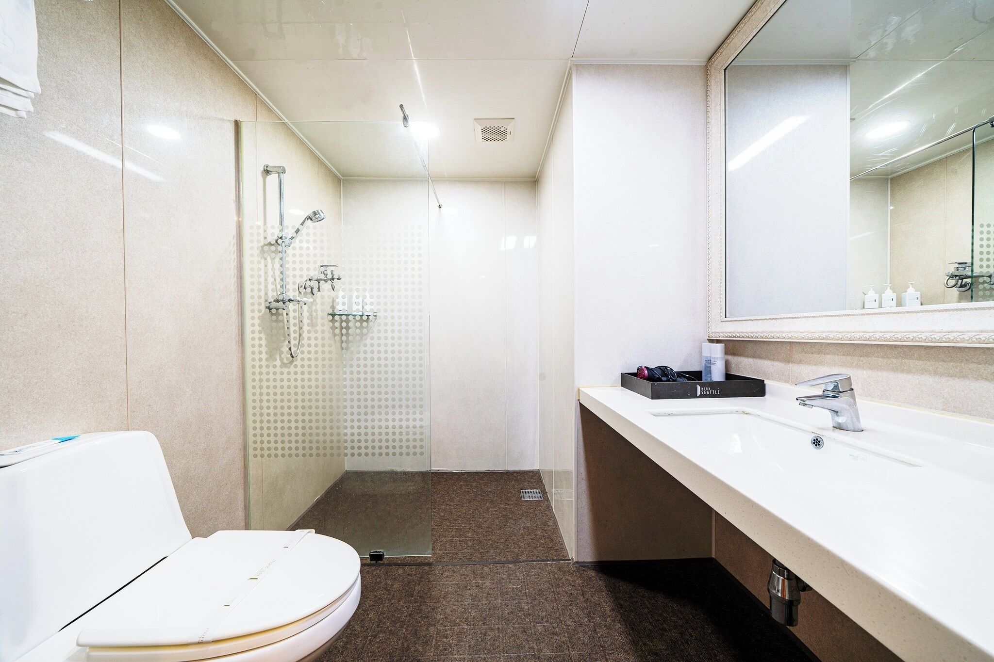 A modern bathroom with a shower, toilet, and sink.