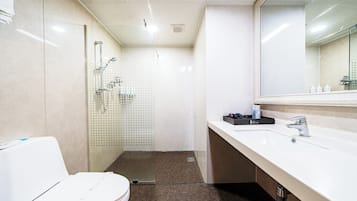 A modern bathroom with a shower, toilet, and sink.