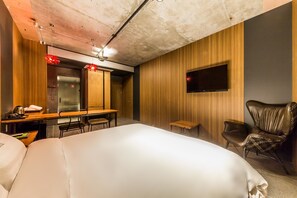 A hotel room with a large bed, a desk with a chair, a television mounted on the wall, and a leather chair. - Hotel Seattle Incheon Airport (Incheon)