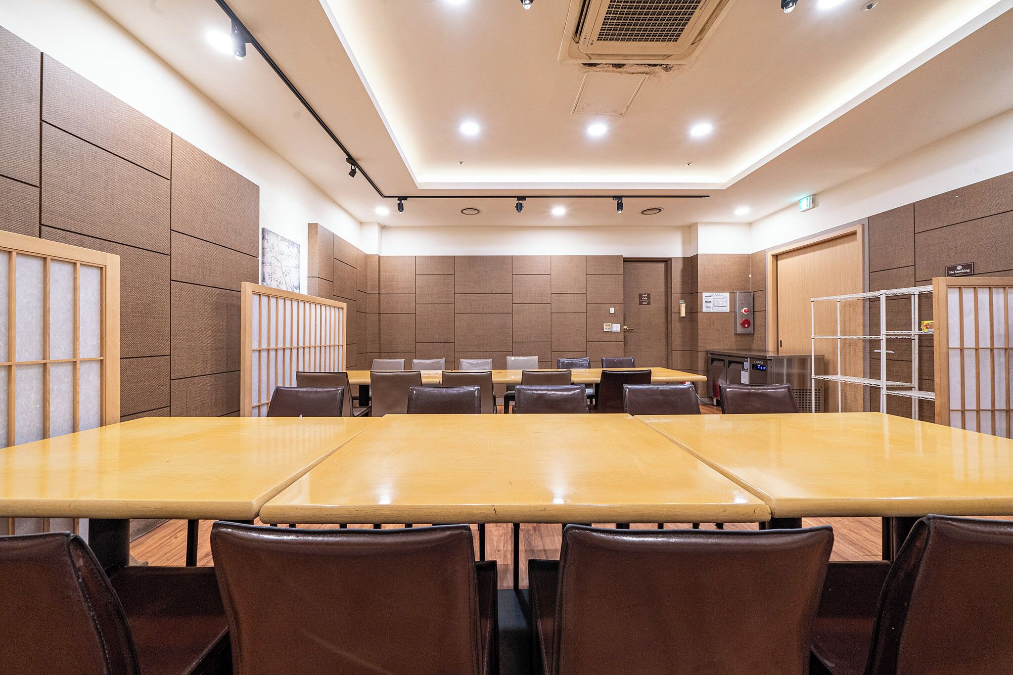 Une salle de conférence équipée d’une longue table, de chaises et d’un petit coin cuisine.