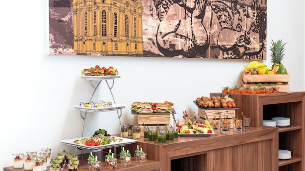 Ein reichhaltiges Buffet mit Speisen und Getränken auf Holzbögen.