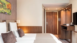 Ein Hotelzimmer mit einem großen Bett, einem Fernseher, einem Kleiderschrank und einem Gemälde an der Wand.