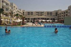 Relax by the pool surrounded by lounge chairs and umbrellas, with stunning views of the hotel's residential-style accommodations.