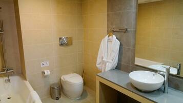 A bathroom with a bathtub, toilet, and sink.