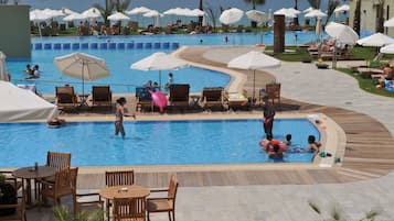 Una piscina cubierta, una piscina al aire libre, sombrillas, tumbonas