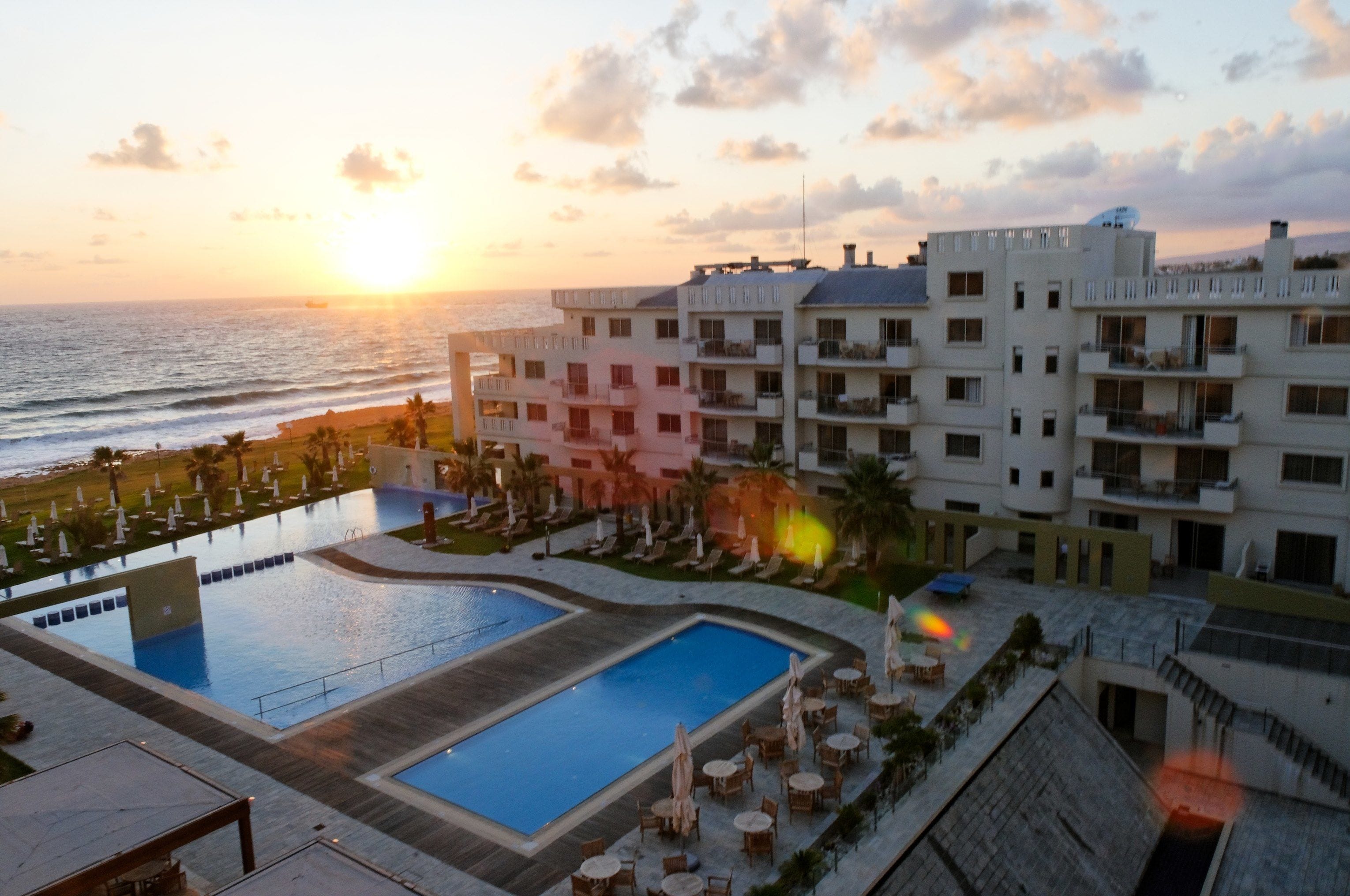A resort with a pool, beach, and ocean view.