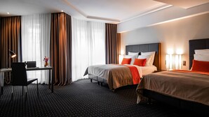 Habitación de hotel con dos camas, un escritorio y una silla.
