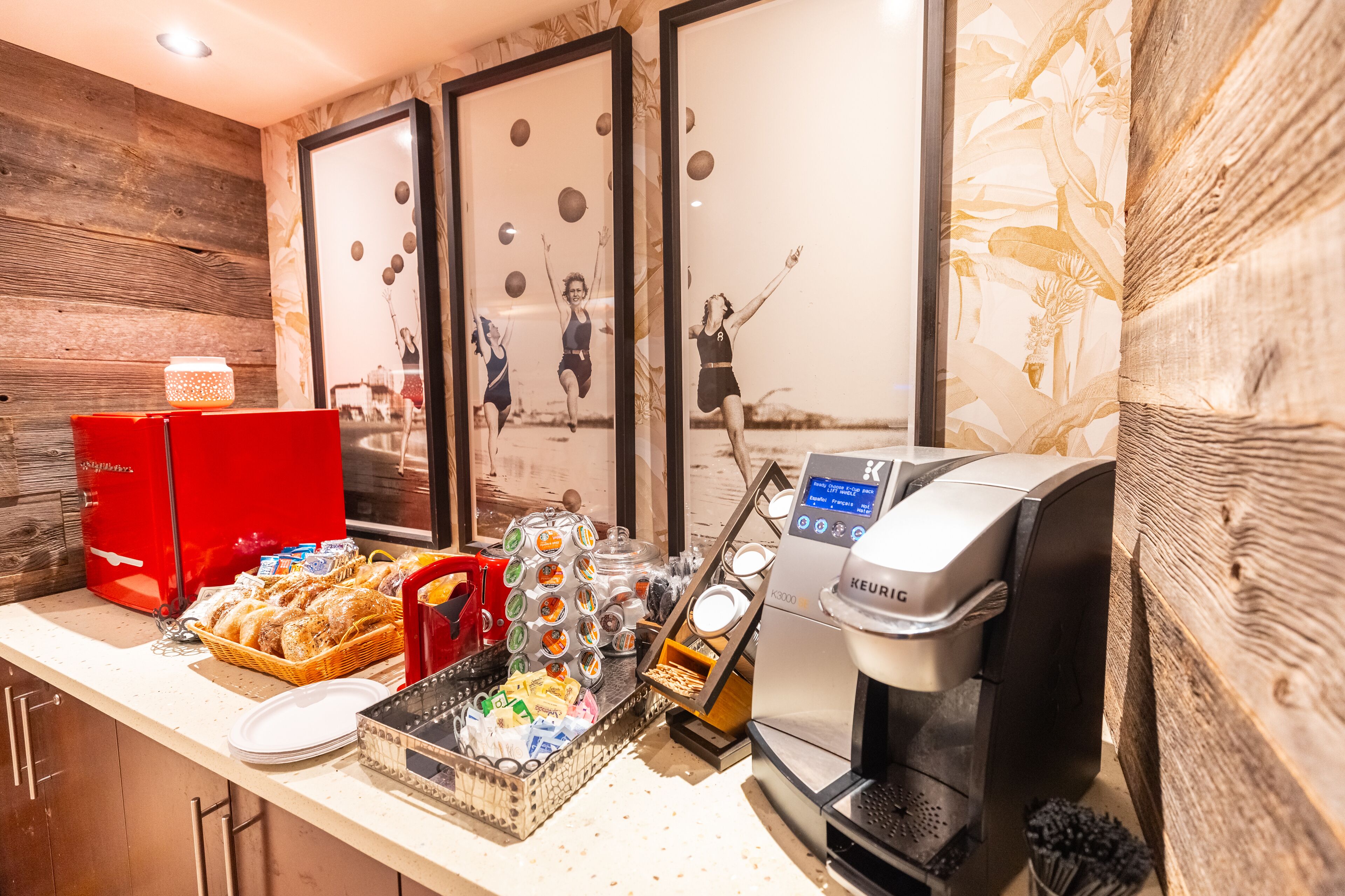 A breakfast bar with a coffee machine, a red coffee station, and various food items.