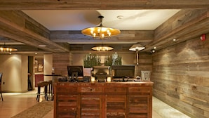 A rustic interior with a wooden bar area, a large chandelier, and a seating arrangement. - Daddy O Hotel (Beach Haven)