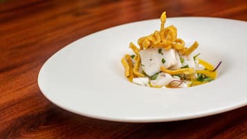 A white plate with a seafood dish on a wooden table.