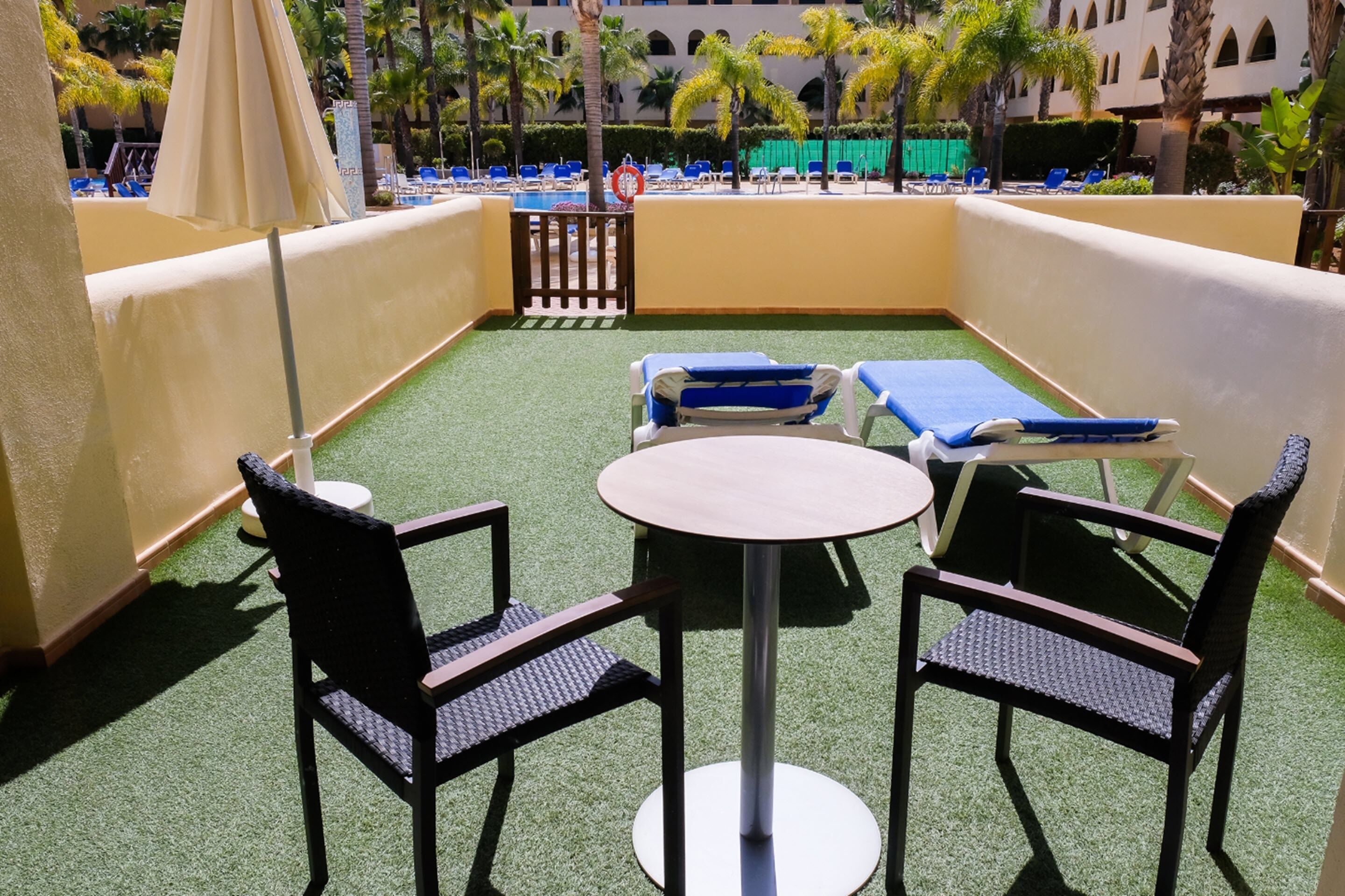 En takterrass med en pool, solstolar och ett bord.
