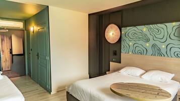 Une chambre d’hôtel avec un lit, une table de chevet et un mur au décor original.