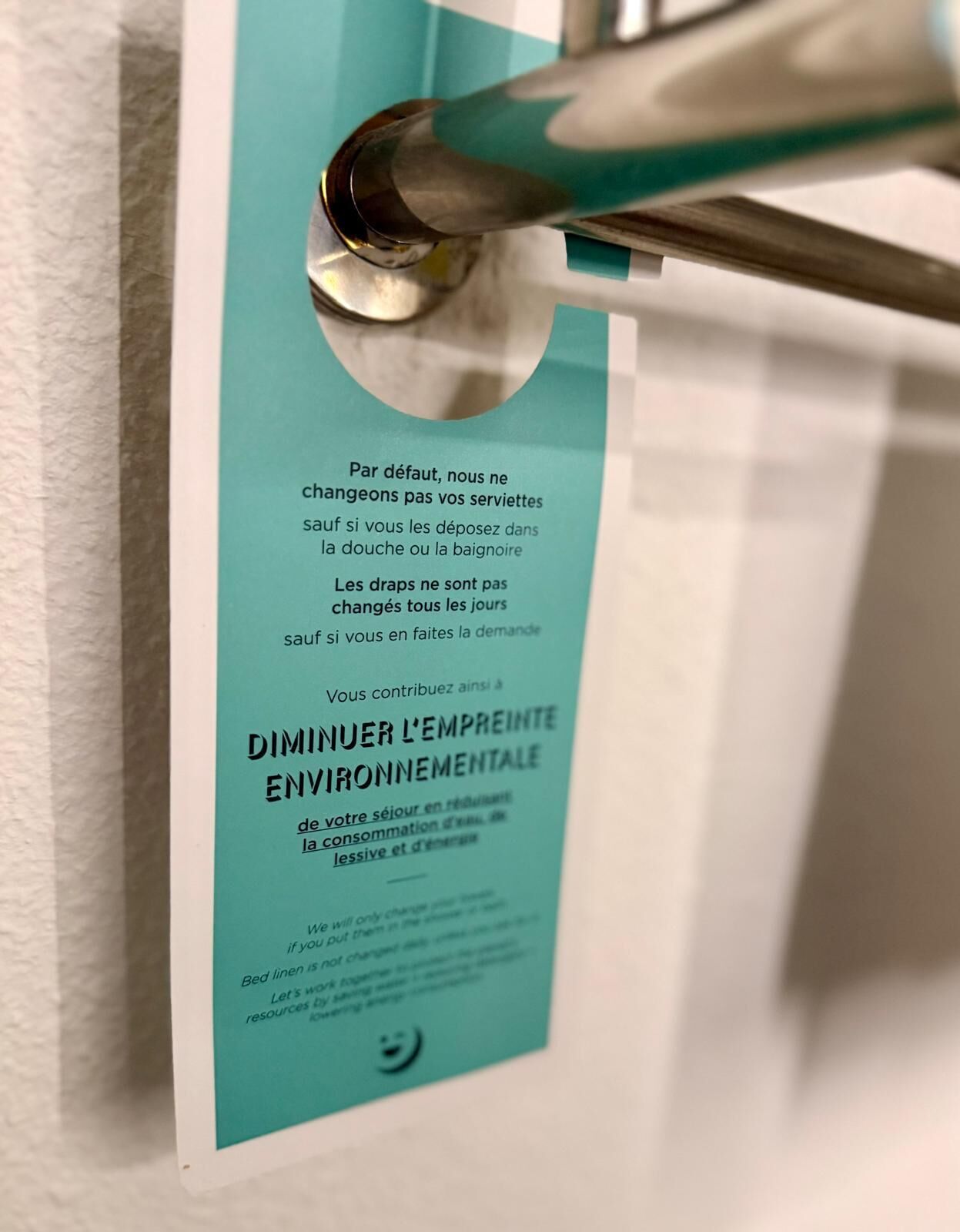 Un letrero con texto en francés, probablemente ofreciendo información sobre servicios u políticas de la habitación.