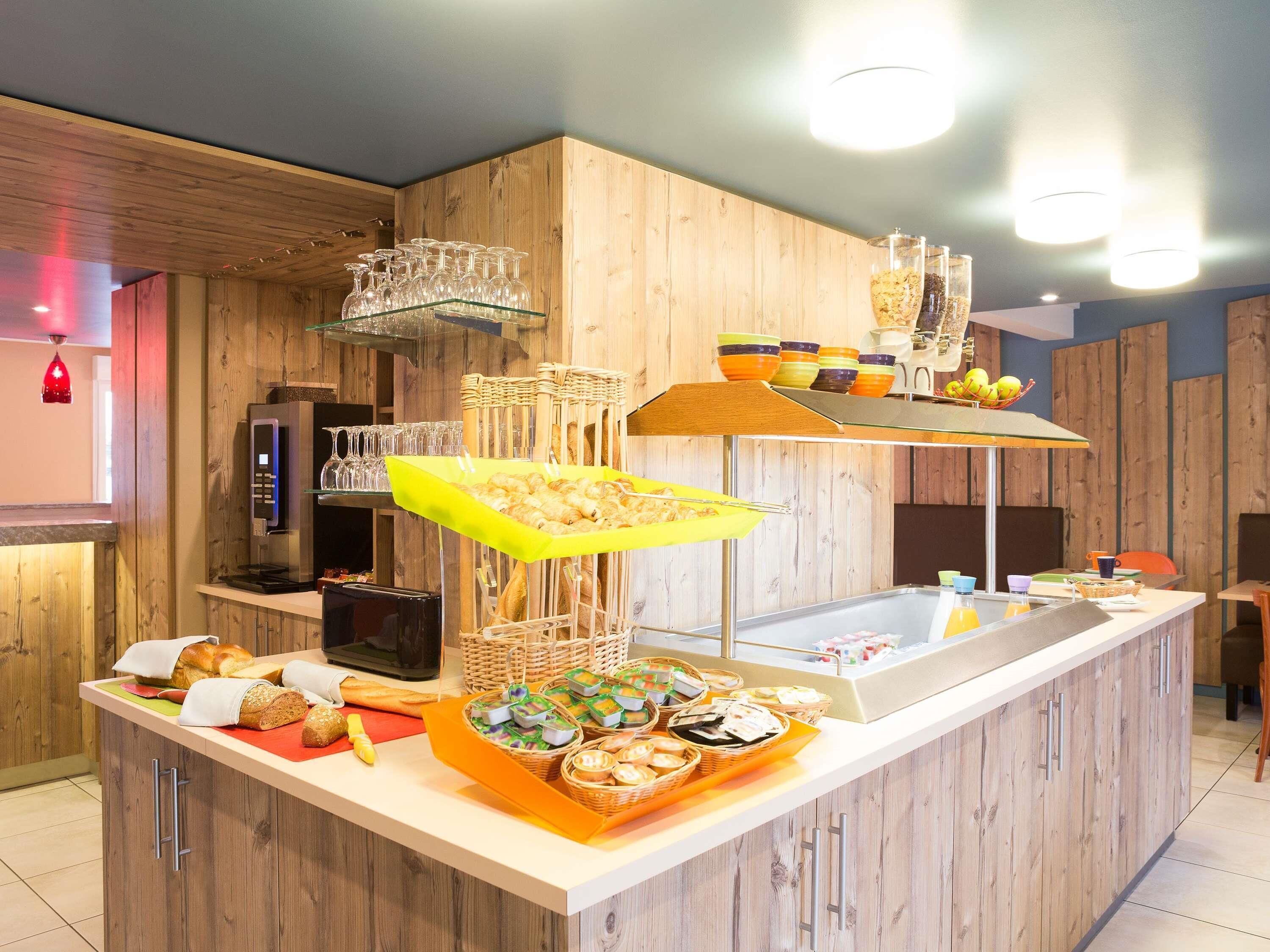 Ein reichhaltiges Buffet mit verschiedenen Speisen, einer Kaffeemaschine und Gläsern.