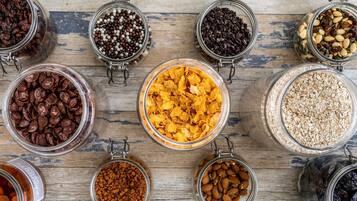 A variety of food items in glass jars on a wooden surface.