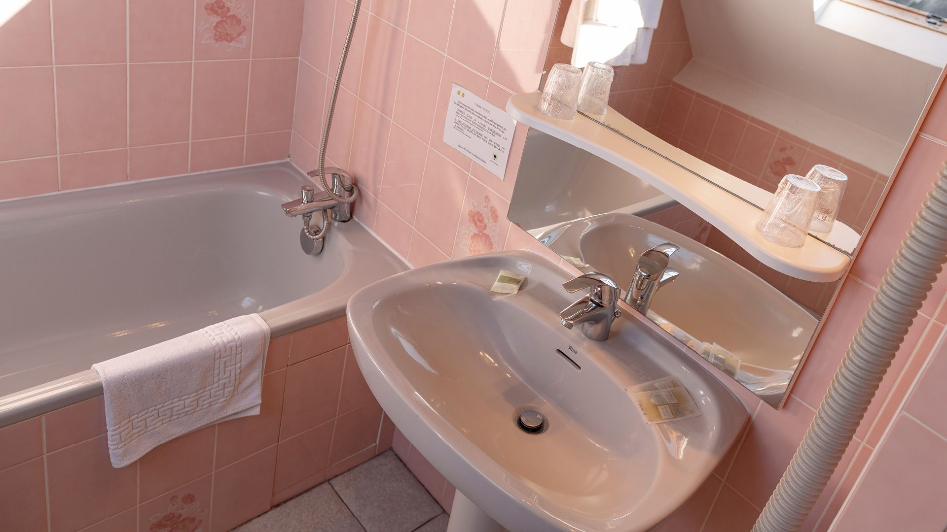 A bathroom with a bathtub, two sinks, and a mirror.