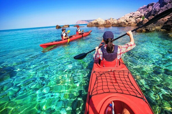 Vista despejada de un kayak sobre aguas tranquilas, con formaciones rocosas al fondo.