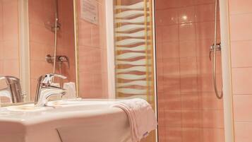 A bathroom with a shower, a sink, and a mirror.
