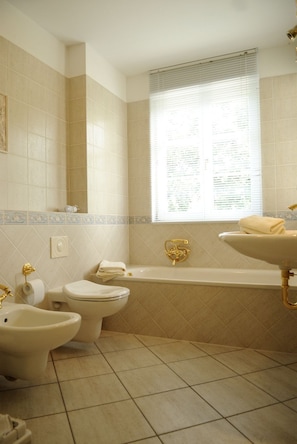 A bathroom with a toilet, bidet, bathtub, and sink. - Elbresidenz Birkwitz (Pirna)
