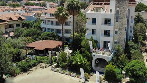 A hotel with a central courtyard, multiple balconies, and a view of the surrounding neighborhood. - Navy Hotel (Marmaris)