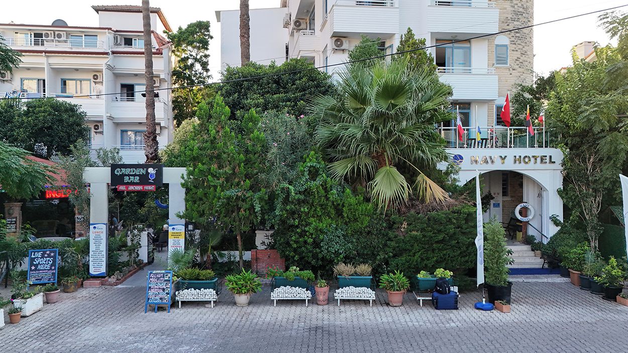 A garden bar, a Navy Hotel sign, and potted plants in an outdoor setting.