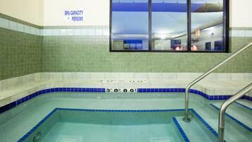 Swimmers can enjoy a rectangular pool with metal handrails and depth indicators.
