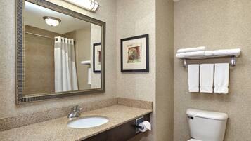 A bathroom with a sink, toilet, and a towel rack.
