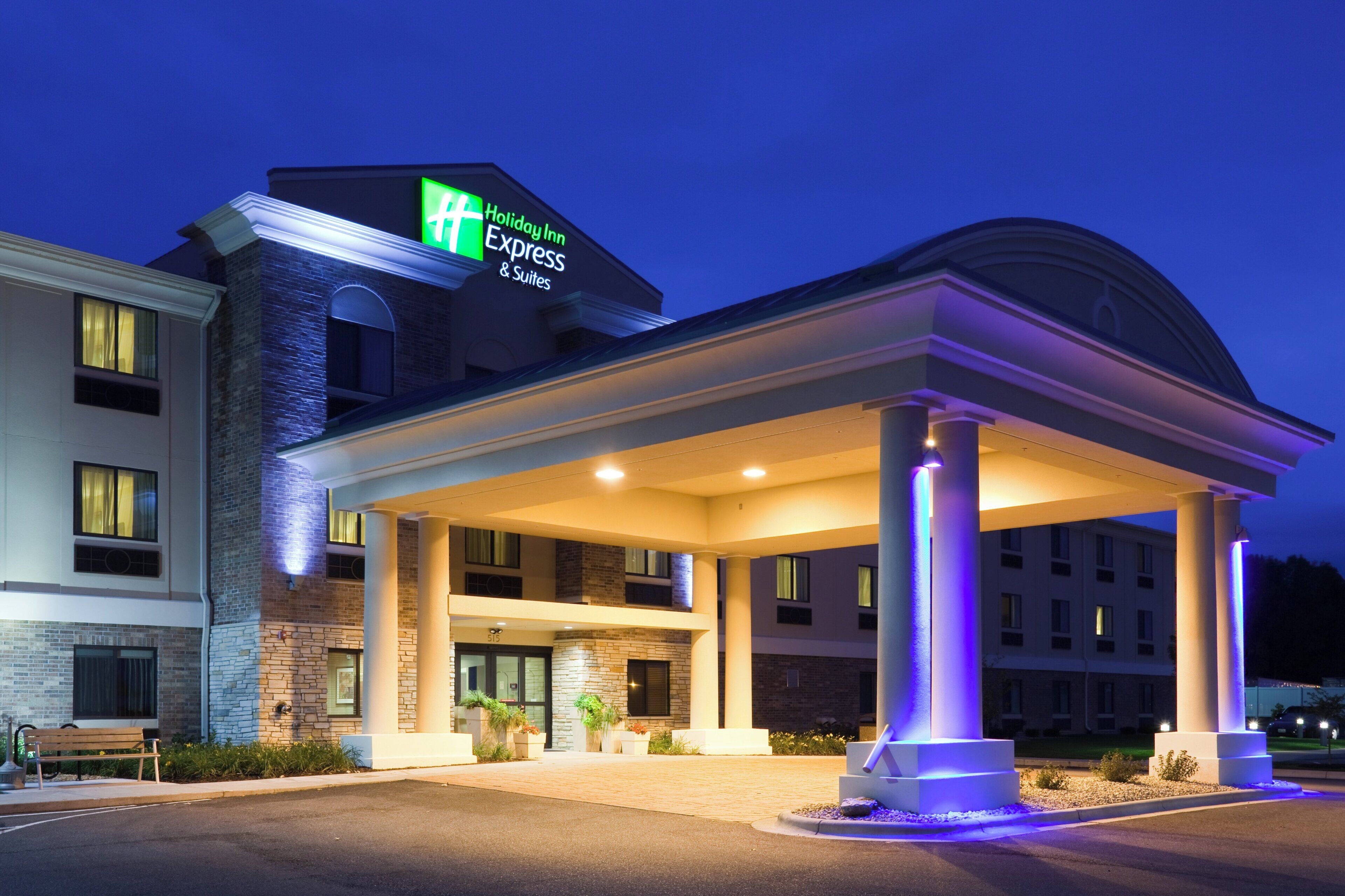 Un hôtel Holiday Inn Express & Suites doté d’une entrée abritée et d’une façade en briques.