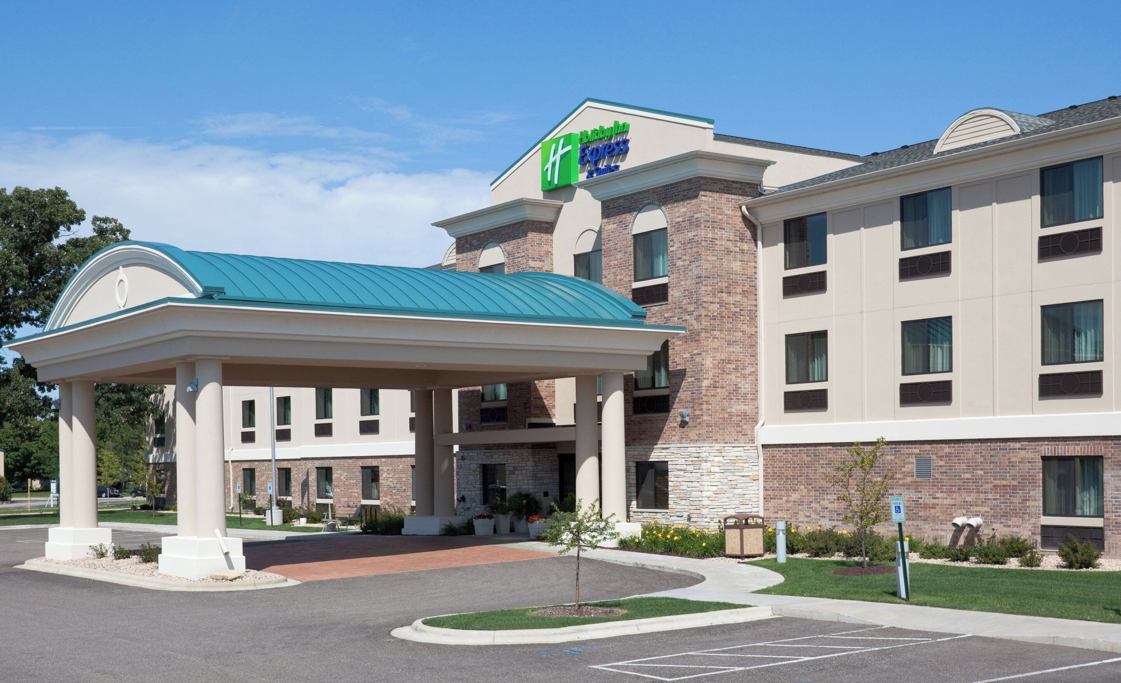 A Holiday Inn Express hotel with a covered entrance, brick facade, and a parking lot.