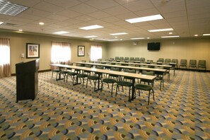 A conference room with a long table, chairs, a podium, and a television screen. - Holiday Inn Express Hotel & Suites Madison-Verona by IHG (Verona)