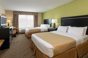 A hotel room with two beds, a desk, a chair, a TV, and a window with curtains. - Holiday Inn Statesboro-University Area by IHG (Statesboro)