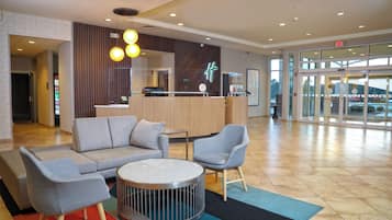 A lobby area with seating, a reception desk, and a glass entrance.