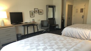 A hotel room with two beds, a desk, a chair, a television, and a dresser. - Holiday Inn Statesboro-University Area by IHG (Statesboro)