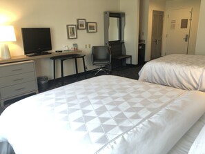 A hotel room with two beds, a desk, a chair, a television, and a dresser. - Holiday Inn Statesboro-University Area by IHG (Statesboro)