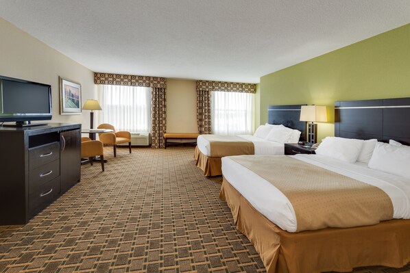 A hotel room with two beds, a desk, a television, and a chair. - Holiday Inn Statesboro-University Area by IHG (Statesboro)