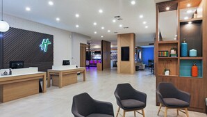 A modern reception area with a reception desk, seating area, and a bar in the background.