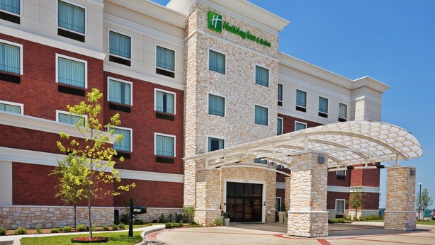 A Holiday Inn Express hotel with a brick facade, multiple windows, and a covered entrance.
