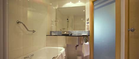 Une salle de bain moderne équipée d’une baignoire, d’une douche et de toilettes.