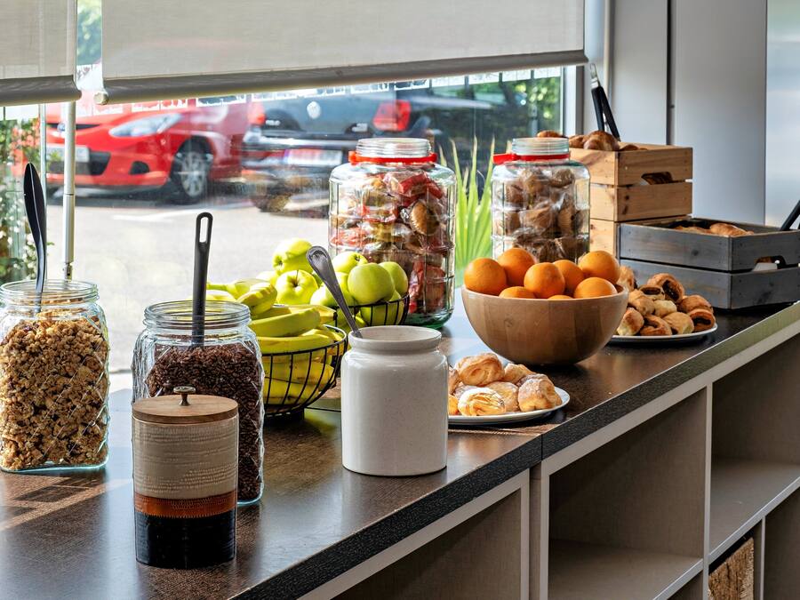 A breakfast buffet with various food items and condiments on a counter.