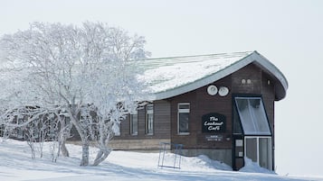 Un bâtiment en bois avec une enseigne indiquant « The Lookout Café », et un arbre au premier plan.