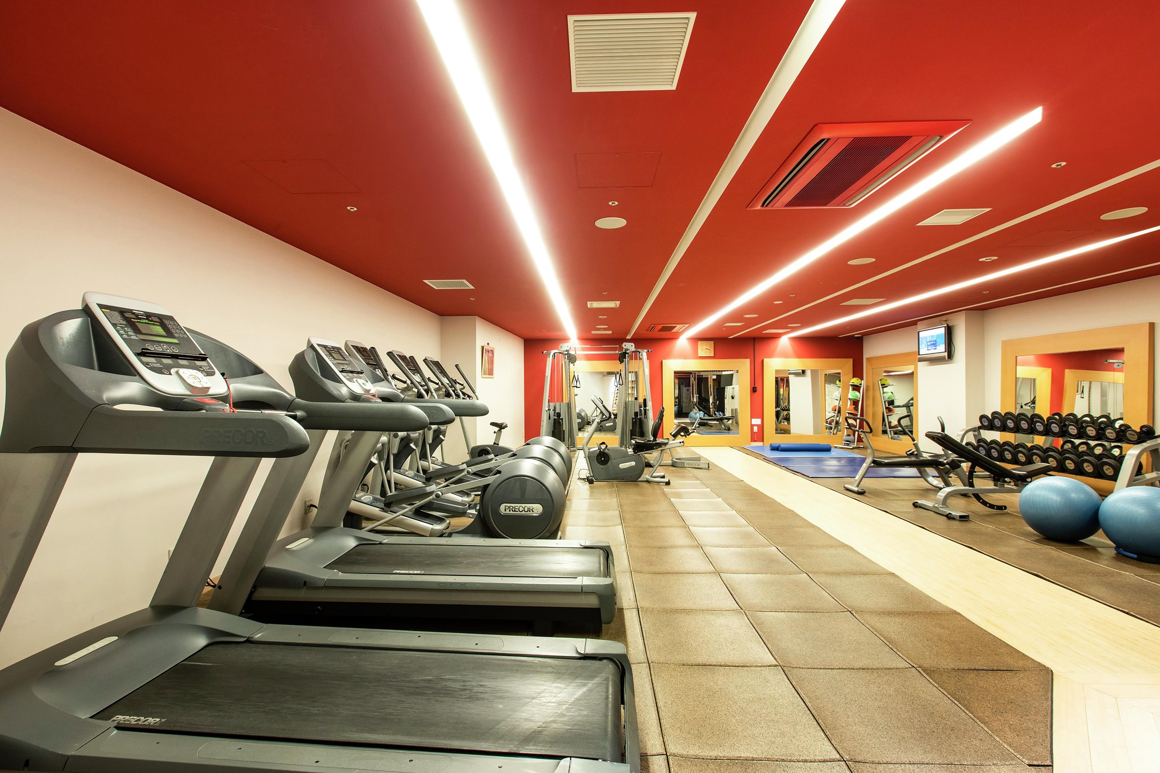 Ein Fitnessstudio mit Laufbändern, Trainingsbällen und Kraftgeräten.