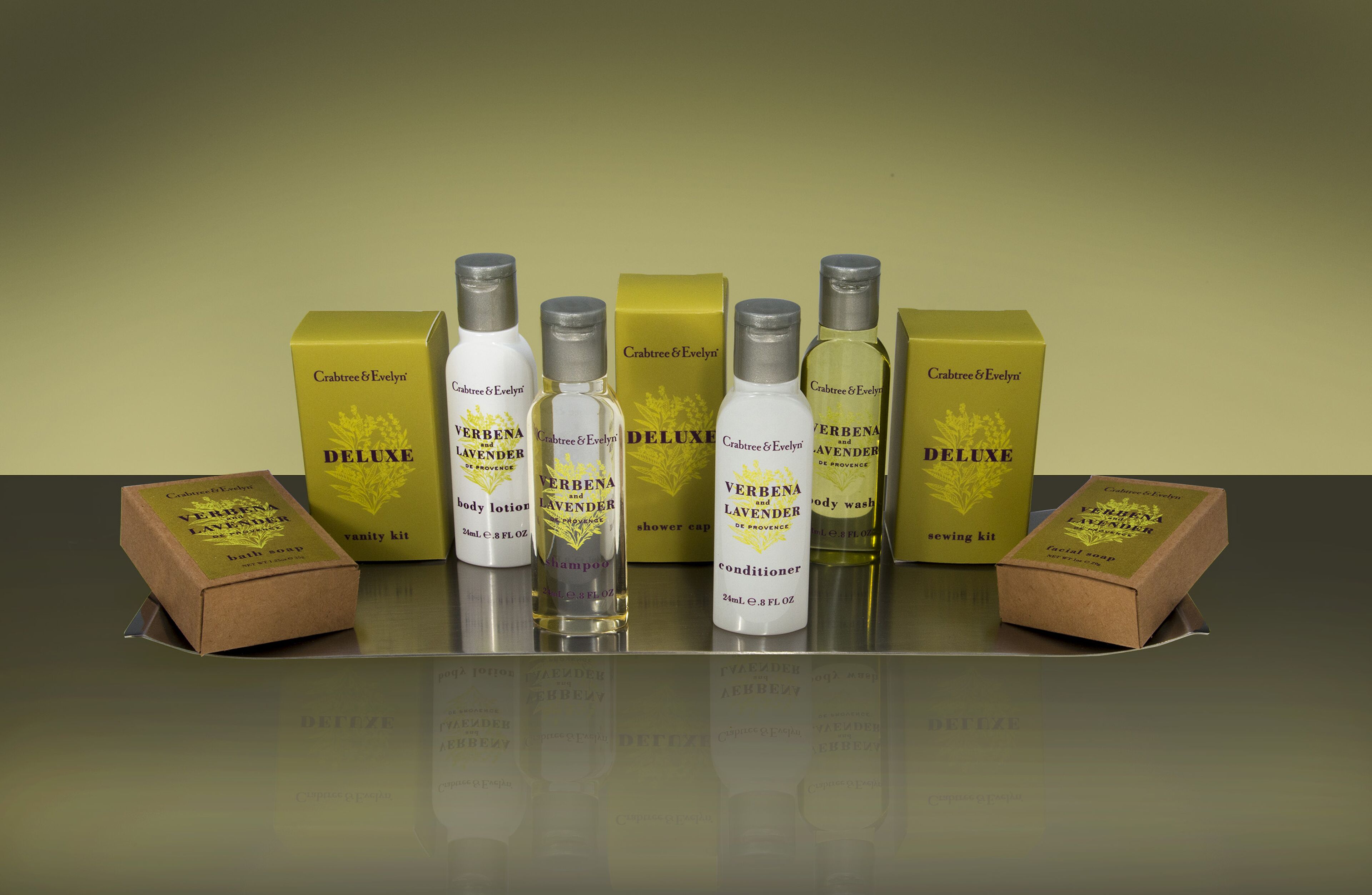 A collection of skincare products including body lotion, shampoo, shower cap, conditioner, and sewing kit.