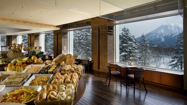 Buffet variat d'aliments amb vista a una muntanya coberta de neu.