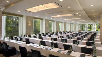 A conference room with long tables, chairs, and large windows.