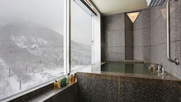 Ein Badezimmer mit großem Fenster, einer Badewanne und einer Duschkabine.
