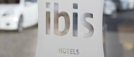 A sign with the word "ibis" and "HOTELS" indicating a hotel chain.