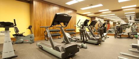 A gym with multiple treadmills, stationary bikes, and weight machines.