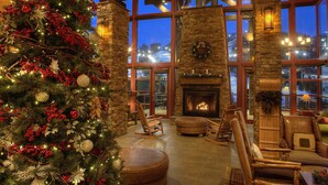 Un interior acogedor con un gran árbol de Navidad, paredes de piedra y una chimenea.