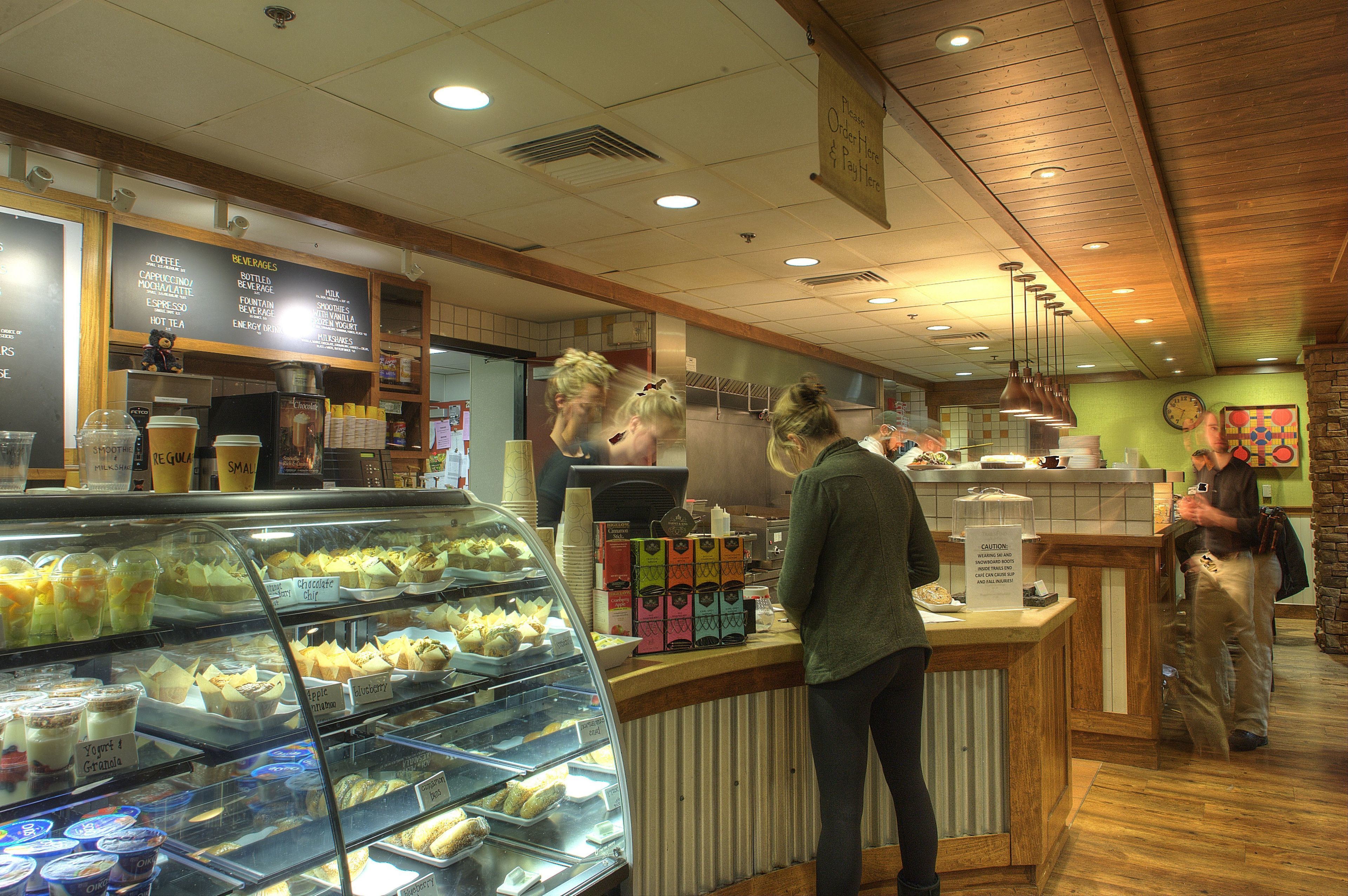 Een bakkerij toonbank met diverse gebakjes en een menubord.